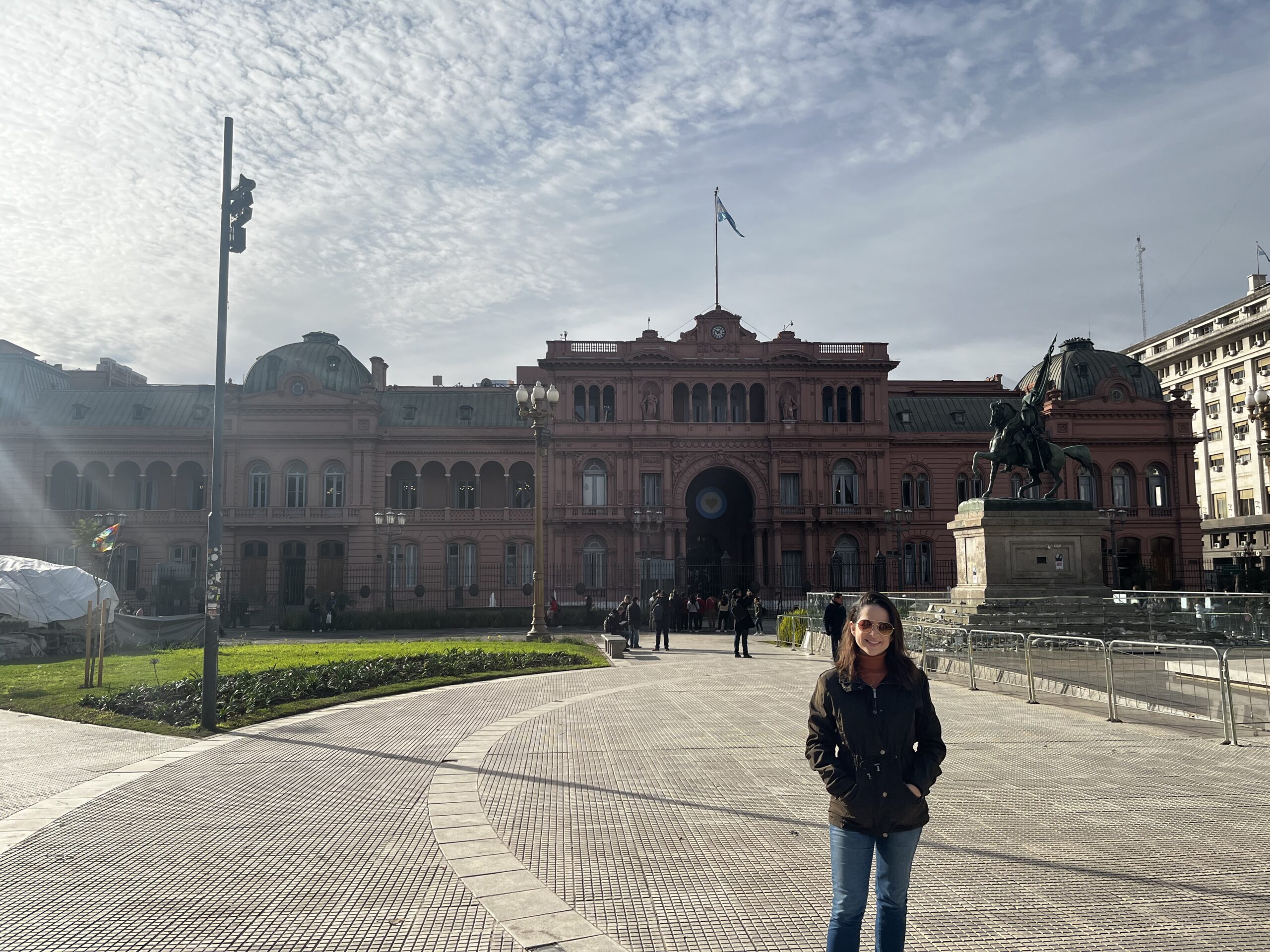 Fachada da Casa Rosada na Plaza de Mayo, Buenos Aires, sob um céu azul.