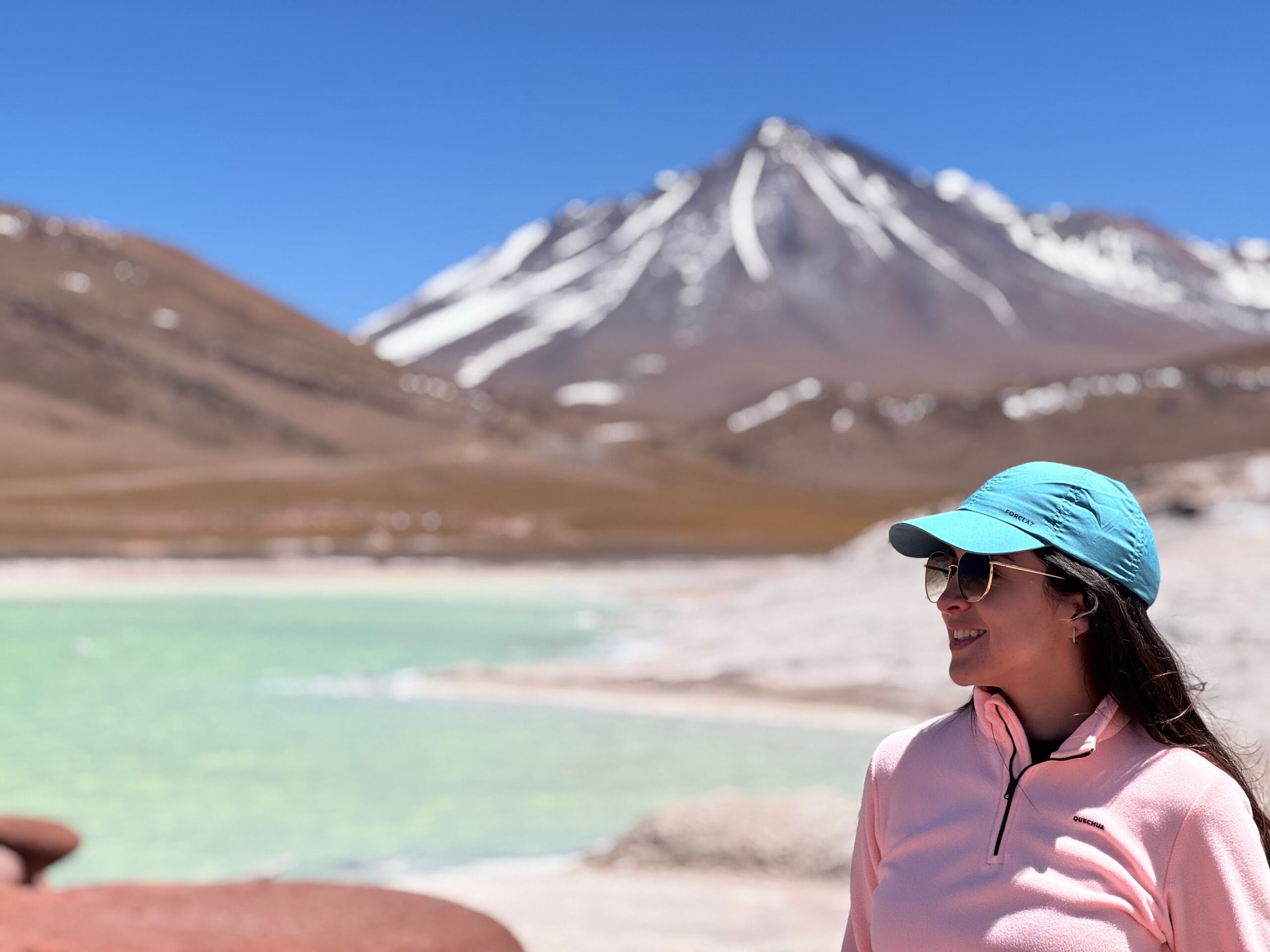 Viajante apreciando a vista panorâmica das Piedras Rojas no Deserto do Atacama sob um céu azul profundo.